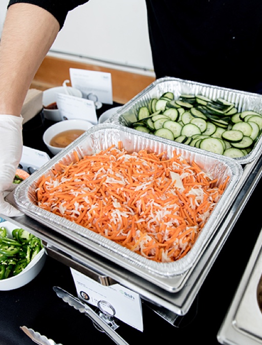A close-up of a tray of freshly grated carrots and chopped cucumbers from Lish catering.